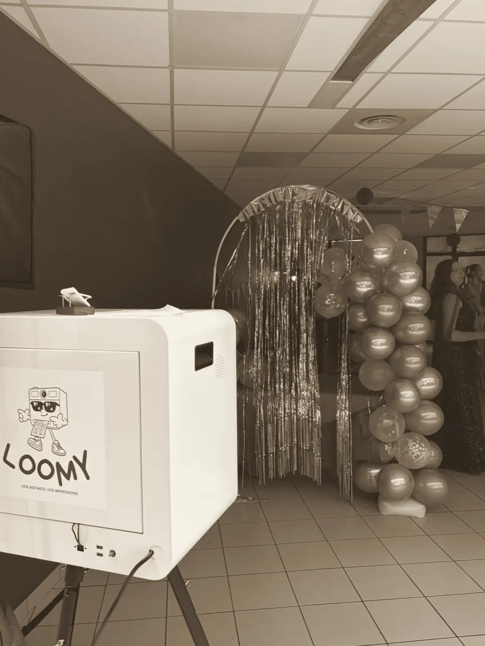 Le photobooth LOOMY à côté d'une arche de ballons dorés lors d'un gala